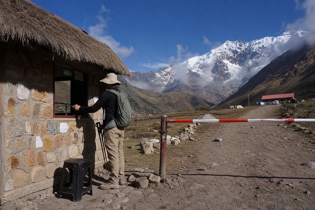 Hiker paying the community entrance fee in soles at the Soraypampa checkpoint before the Humantay trail